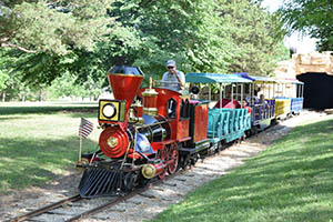 Mini-train at tunnel with engineer waving